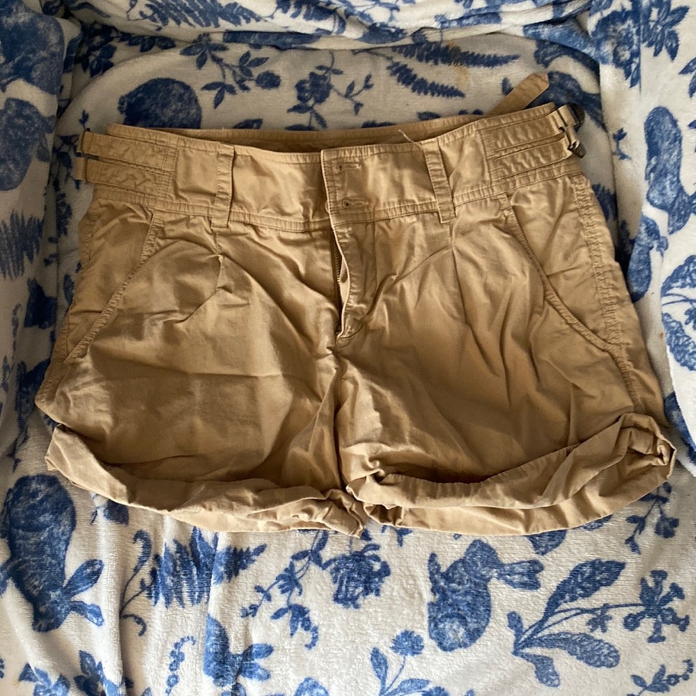 Beige military style shorts, decorative belt buckles along waist